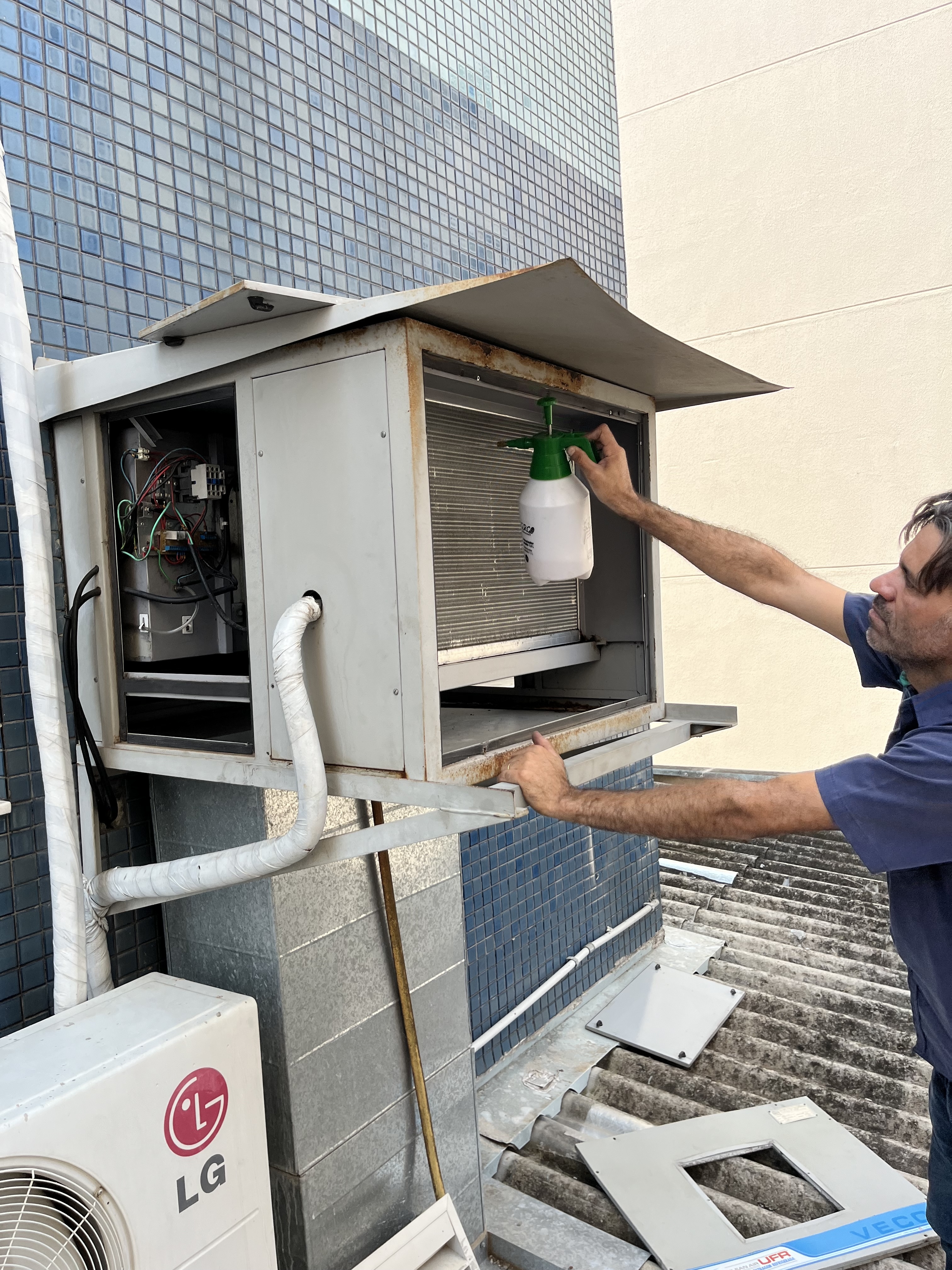 Técnico FAS Brasil realizando manutenção de ar-condicionado em ambiente corporativo